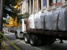 A flatbed trailer of rooflite extensive mc waits for the crane on a closed street
